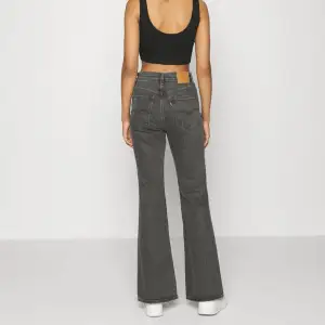 Gråa jeans från Levis i modellen ”70’s high flare”. De är lite slitna längst ned (se bild). 