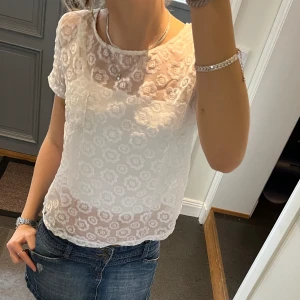 Vit spetstopp - Vit t-shirt i spets med blommönster från Abercrombie & Fitch i storlek S. Fint skick. Använd gärna köp nu!
