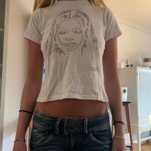 Baby Tee med tryck i silver - Snygg baby tee med tryck i glittrigt silver på. Skön och snygg och väldigt snygg passform