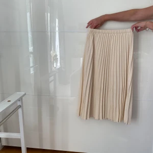 Jätte fin midikjol som tyvärr inte passar längre - Köpte den för några år sedan och har tyvärr blivit liggande då den är för liten. Skulle säga att den är créme färgad/vanilj vit.  Bredd: ca 33cm(resårband-töjbar  Längd: 75cm