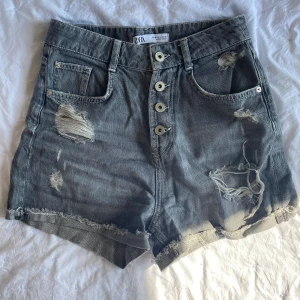 Jeansshorts Zara - Grå jeansshorts med slitningar från Zara. Superfina! Högmidjade. Säljer då dom tyvärr blivit försmå för mig. 
