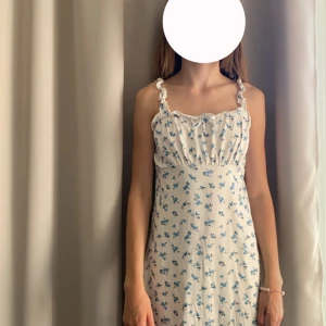 Vit klänning med blåa blommor på - Användning 1 gång, blå blommig klänning från SHEIN. Säljer för den inte är min stil längre.