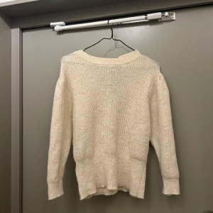 Stickad tröja - Stickad tröja från mango i ull blandning. Jätte söt i ryggen med band man kan knyta till en rosett exempelvis!