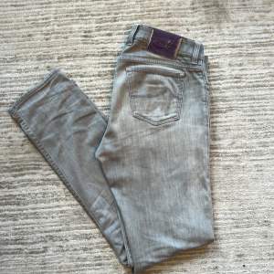 Gråa Jacob Cohen jeans I bra skick förutom liten nötning med lila backtab. Modellen är 688 comfort vilket sitter slimfit med massa fina exklusiva detaljer från det italienska märket. Passar W32-34   Känn er välkomna att ställa frågor  Mvh Agaton 