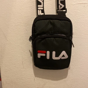 Fila bag - Liten FILA väska, praktisk och funkar perfekt. Lite trasig inuti men den funkar bra ändå