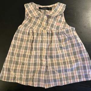 Baby klänning från Burberry London Passar storlek 3-6 månader Fint skick förutom någon enstaka fläck på bröstet som inte har blivit behandlad, därav priset.