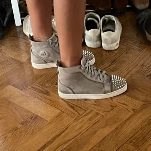 Christian Louboutins sneakers - Säljer mina Christian Louboutin sneakers i grå mocka med spikar fram. Hög modell. Slitna så säljer de bara för 2 500 kr! Har box dustbag påse allt ingår i köpet. Möts i Stockholm eller fraktar! 