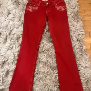 Så snygga Lågmidjade utsvängda röda jeans. Dem är insydda i midjan. Passar en s/m. Midjemått 38 cm och innerbenslängd 81 cm. Dem är helt nya med prislapp.