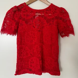 Röd spetstopp - Endast använd ett fåtal gånger. Storlek XS men det stretchiga materialet gör att den sitter utmärkt på S och M också.