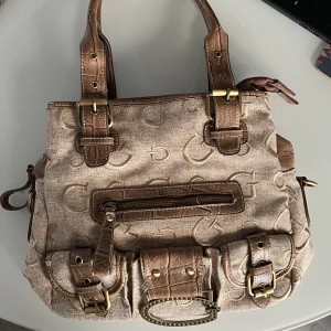 Guessväska - Fin guessväska i superfint skick! Tre stora fack med mindre fack i alla, tre mindre på framsidan. Pris går att diskutera! Mått: 27 på höjd, 33 i bredd