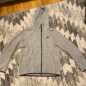 Nike Tech Fleece Old season - En grå Nike Tech Fleece kofta den äldsta modellen som ej säljs längre, endast använd ett par 2-3 gånger då den köpts av reseller så i princip nytt skick på den. Storlek M, skulle säga att den även passar om man brukar ha S.