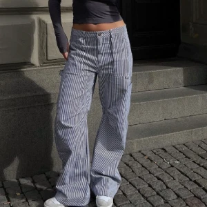 Randiga cargobyxor - Blåvit-randiga low waist cargobyxor från Bershka i väldigt bra skick!❣️