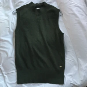 Olivgrön tygväst - Nästan aldrig använd! Passar bra att ha över skjortor som en väst eller bara som tröja:)