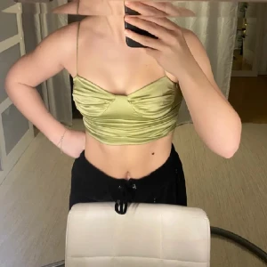 Grön satintopp från Gina tricot! - En jättefin satintopp som tyvärr är för liten för mig! Den är i fint material och inte alls tunn eller genomskinlig! Bara använd en gång!