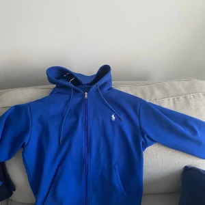 polo ralph lauren zip hoodie - en blå polo ralph lauren zip hoodie i nyskick, skriv om ni har några funderingar