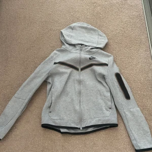 Nike tech - Nike tech grå  Säljer en Nike tech i färg grå storlek xs Har växt så passar inte mig längre men är riktigt sjön och Nice och ha på sig👍