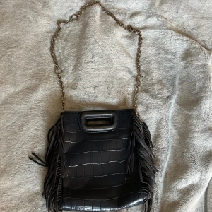 Maje väska - Maje väska, väldigt använd och sliten därav priset. Hela texten där de ska stå maje har suddats ut vid användning. Den har också en defekt vid där man hakar i bandet som man kan se på bilden 