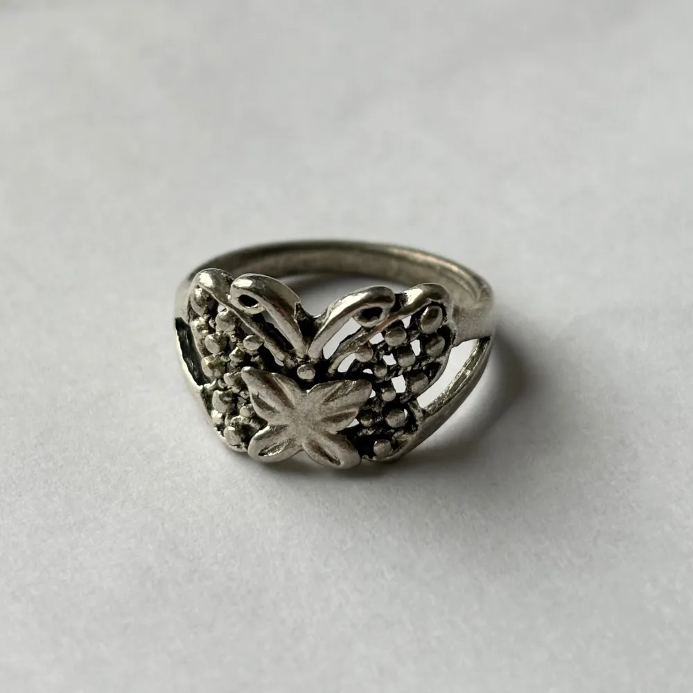 En fin ring i motivet av en fjäril. Osäker på material. Den rostar ej men känns inte som stainless steel heller, kan vara järn? I fint skick iaf. Kan skicka privat med brev, frakten blir då bara 18 kr.. Asusteet.