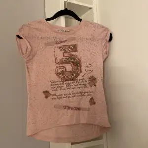 Rosa t-shirt med text och motiv på