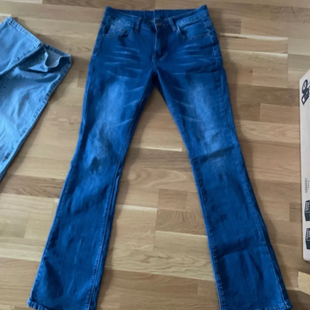 Jättesnygga lowwaist utsvängda blåa  jeans med snygg slitning💕mycket bra skick förutom två små färgfläckar som man knappt märker men har sänkt priset därefter☺️storlek S. Står inget märke i jeansen vad jag hittar tyvärr. Jeans & Byxor.