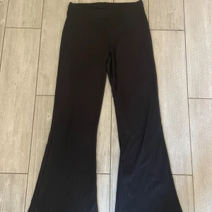 Svarta ribbade utsvängda byxor - Svarta ribbade timmes utsvängda byxor. Väldigt fladdriga med skönt material!
