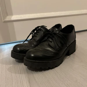 svarta skor med liten klack  - relativt använda skor men dem är i helt okej skick förutom på höger sko (se bild), har försökt få bort reporna men inte lyckats.