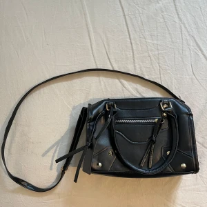 Handväska - Snygg väska med gulddetaljer som är oanvänd pga att jag inte gillar guld💕