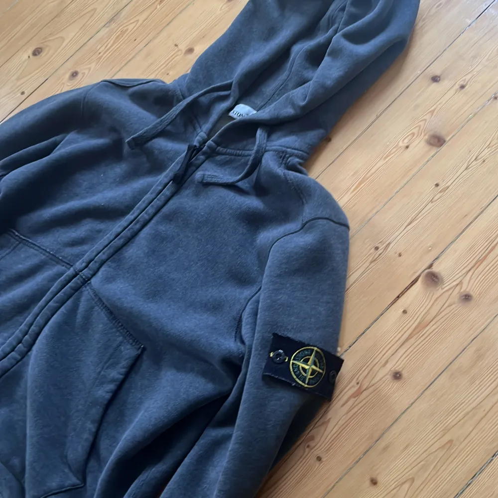 Säljer denna stone island zip hoddien. Den är sparsamt använd. Säljer denna då den är för liten. Den är mörkgrå i färgen och är i bra skick , nypriset ligger på ca 3000kr.. Hoodies.