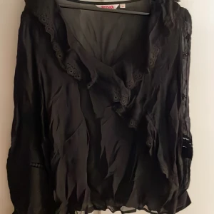 Genomskinlig blus - Snygg genomsklinlig blus med ryschad v-ringning.