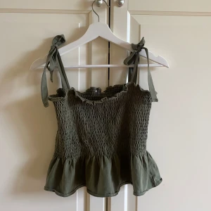Grön volang topp - Använd fåtal gånger, passar storlek xs/s. Banden är justerbara eftersom man knyter de själv. Kanten längst ner behöver strykas ner🌸