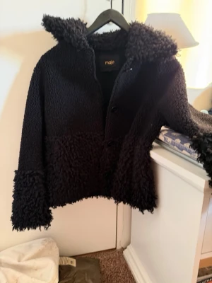 Svart teddyjacka från Maje - Säljer en svart teddyjacka från Maje med fluffig struktur, ny går för ca 5 tusen och den är knappast använd! 