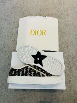 Dior Walk Dam Skor - Säljer nu ett par Dior sneakers i skick som nytt(använd up till 3 gånger) storleken är 39 och färgen är beiche samt navy blue. Har vart sparsamt använda och redo för en ny ägare. ~Hör av dig vid funderingar eller budförslag❗️Postar alltid inom 24 timmar✅📦