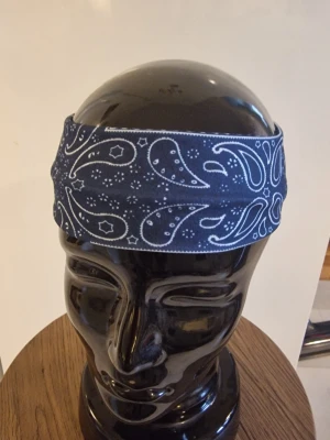 Bandanas/hårband cachewnöt mörkblå - Bandanas/hårband cashewnöt. Elastisk. 23,5 cm huvud. Bredd 6 cm. Trikåtyg. Polyester.