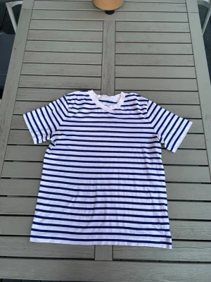 Randig t-shirt från Arket - Säljer en randig T-shirt från arket. Den här tröjan är perfekt för sommaren och sena sommarkvällar. Tröjan är från arket och bär storlek S men om du ligger i storlek xs så Kmr den att passa extremt bra på dig även om du vanligtvis har xs! Skriv Järna om du har några funderingar och glöm inte att priset kan förhandlas!
