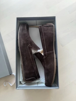 Bruna mockaloafers med gummisula från vagabond  - Snygga loafers i mörkbrun mocka med klassisk design och diskreta sömmar. Skorna har en mjuk ovandel och en ljusbrun gummisula som ger bra grepp. Perfekta för en stilren och avslappnad look. Nypris 1699kr från scorett