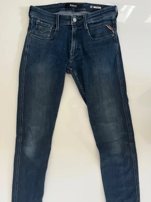 Replay anbass jeans - Snygga mörkblå skinny jeans från Replay med klassisk femficksdesign och subtila slitningar. Jeansen har en smal passform och är tillverkade i stretchigt denimtyg för extra komfort. Perfekta för en trendig och avslappnad look.