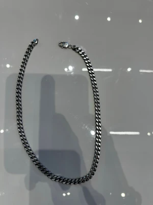 Kedjehalsband i silver - Snyggt äkta silver halsband med breda, platta länkar i silver.  Kedjan har en klassisk karbinhake och ger en stilren och modern vibe. Perfekt för dig som gillar minimalistiska accessoarer med lite edge. Nypris ligger på 3500kr 