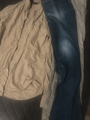 Beige skjorta från Polo Ralph Lauren - Klassisk beige skjorta från Polo Ralph Lauren med button-down krage och broderad logga på bröstet. Skjortan har långa ärmar och knäppning framtill. Perfekt till jeans eller chinos för en clean och stilren look. Båda Jensen nudje W 32 L 32 & Replay W 33 L 32 och S Ralph skjorta beige för 1299kr