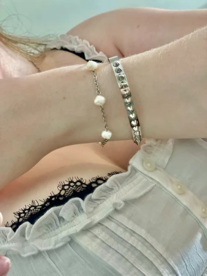 Handgjort armband med äkta sötvattenspärlor & rostfritt stål - Elegant handgjort armband med äkta sötvattenspärlor och kedja i rostfritt stål. Ett stilrent smycke som passar både till vardags och fest. • Handgjort • Äkta sötvattenspärlor • Rostfritt stål • Längd: 20 cm • Tåligt och tidlöst Varje pärla är unik och kan variera något i form och utseende, vilket gör varje armband speciellt. 📦 Skickas väl emballerat.