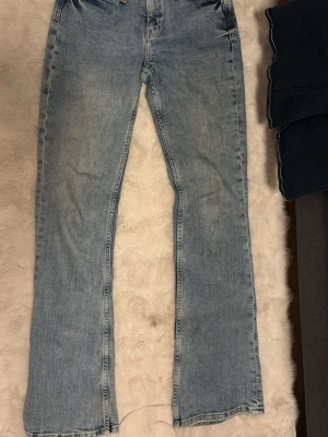 Ljusblå bootcut jeans med låg midja - Säljer ett par ljusblå jeans med bootcut-modell och låg midja. Jeansen har klassisk femficksdesign och är tillverkade i ett mjukt denimtyg. Perfekta för dig som gillar en avslappnad och trendig look.
