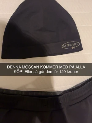 Svart mössa från Starlight - Snygg svart mössa från Starlight med broderad logga framtill. Klassisk och enkel design som passar till det mesta. Tillverkad i mjukt och stretchigt material för skön passform.
