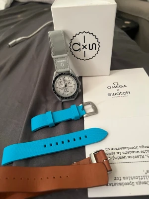 Omega x Swatch MoonSwatch klocka -  Omega x Swatch MoonSwatch använd ett fåtal gånger kommer även med 2 extra band till de som gillar att variera stil och även look på klockan. Klockan är väldigt unik och sticker ut med sin särskilda personlighet klockan kan användas till många olika tillfällen klockan har inga defekter och kommer med original box 