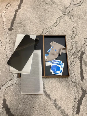 Svart skärmskydd i härdat glas - Säljer ett svart skärmskydd i härdat glas för mobil. Skyddet har en modern design med urtag för kamera och sensorer. Medföljer rengöringsduk och klistermärken för enkel applicering. Perfekt för att skydda din mobil mot repor och stötar.