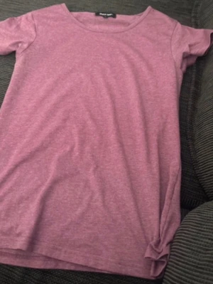 Rosa t-shirt från Take Off - Enkel och snygg rosa t-shirt från Take Off i storlek L. T-shirten har rund halsringning och korta ärmar, perfekt för en avslappnad stil. Tillverkad i mjukt bomullsmaterial som känns skönt mot huden.