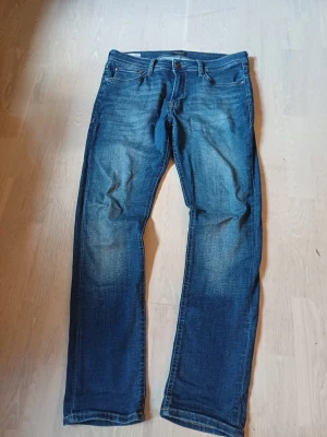 Blå raka jeans  - Snygga blå jeans med raka ben. Klassisk femficksmodell med knapp- och dragkedjegylf. Perfekta till en avslappnad stil. Materialet är denim i bomull.