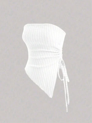 Vit ribbad tubtopp  - Trendig vit ribbad tubtopp med asymmetrisk nederkant och snörning i sidan. Toppen är ärmlös och har en bandeau-passform som sitter tight mot kroppen. Perfekt för att skapa en cool och stilren look.