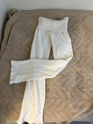 Vita stickade yoga pants - Mysiga vita loungewear-byxor från Gina Tricot med bred ribbad midja och raka ben. Byxorna är stickade och perfekta för hemmamys. Materialet är mjukt och stretchigt för extra komfort. Strl 146-152 men passar mig som 156