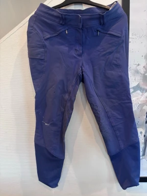 Mörkblå ridleggings med fickor - Snygga mörkblå ridleggings med praktiska fickor på sidorna och silikonmönster på insidan av benen för extra grepp. Hög midja och dragkedjor vid fickorna. Perfekta för dig som gillar att rida och vill ha bekväma leggings med bra passform. Dock en fläck av målarfärg på sig