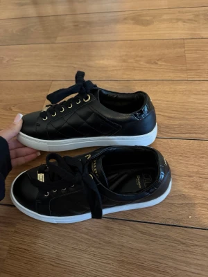 Svarta sneakers från Dune London - Stilrena svarta sneakers från Dune London med vita sulor, guldfärgade detaljer och svarta skosnören. 