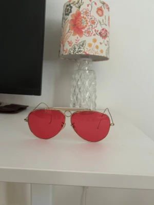 Ray-Ban aviator solglasögon rosa - Ray-Ban RB3138M aviator solglasögon med tunna guldfärgade metallbågar och stora, droppformade rosa glas. Klassisk pilotmodell som ger en retro och cool vibe. Helt i nyskick inga repor. Kan gå ner i pris vid snabb förhandling 